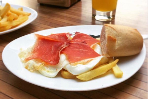 Huevos fritos con jamón y patatas fritas.